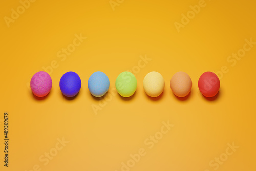 Pattern from rainbow chicken eggs on yellow background top view. Creative food minimalistic background. Preparation for easter. Magic natural food. Eggs painted with rainbow colors.