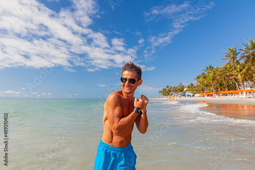 athletic, tanned man with a naked torso on a Caribbean beach