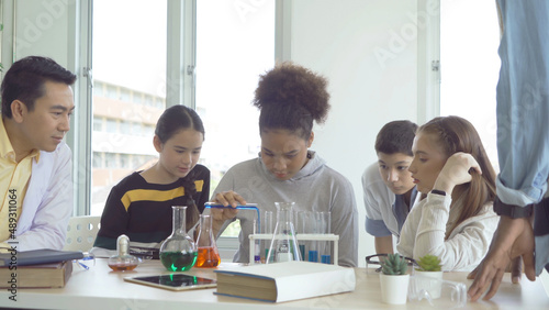 A group of multi ethnic of students kids and teachers study, learn on test tube in lab or laboratory in school, medical, chemistry. Experiment science. Education in classroom. People lifestyle