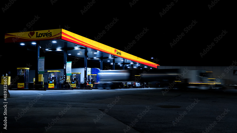 Love's gas station at night with semi trucks parked in fuel islands
