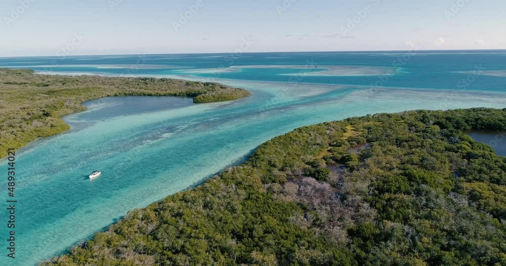 Aerial approach over Boat Sailing in blue waters canals in tropical Forest Mangrove in los Roques Venezuela. Aerial approach over Boat Sailing in blue waters canals in tropical Forest Mangrove in los Roques Venezuela.