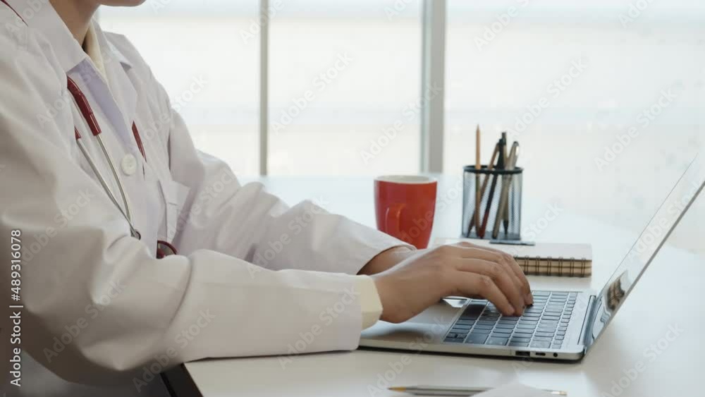 4K 50fps, Close-up of Asian female doctor typing patient report on laptop computer in hospital room 4K 50fps, Close-up of Asian female doctor typing patient report on laptop computer in hospital room
