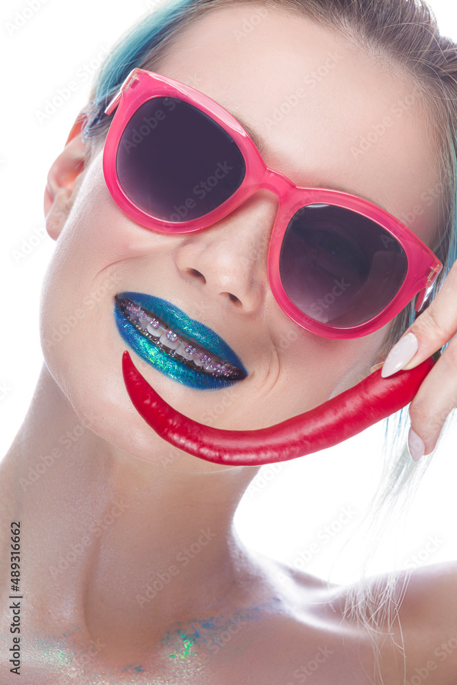 Portrait of Funny Laughing Caucasian Girl Wearing Teeth Braces Having Fun With Red Pepper Against White. Portrait of Funny Laughing Caucasian Girl Wearing Teeth Braces Having Fun With Red Pepper Against White.