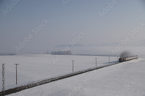 Red diesel train (East express) in motion at the snow covered railway platform - The train connecting Ankara to Kars - Turkey