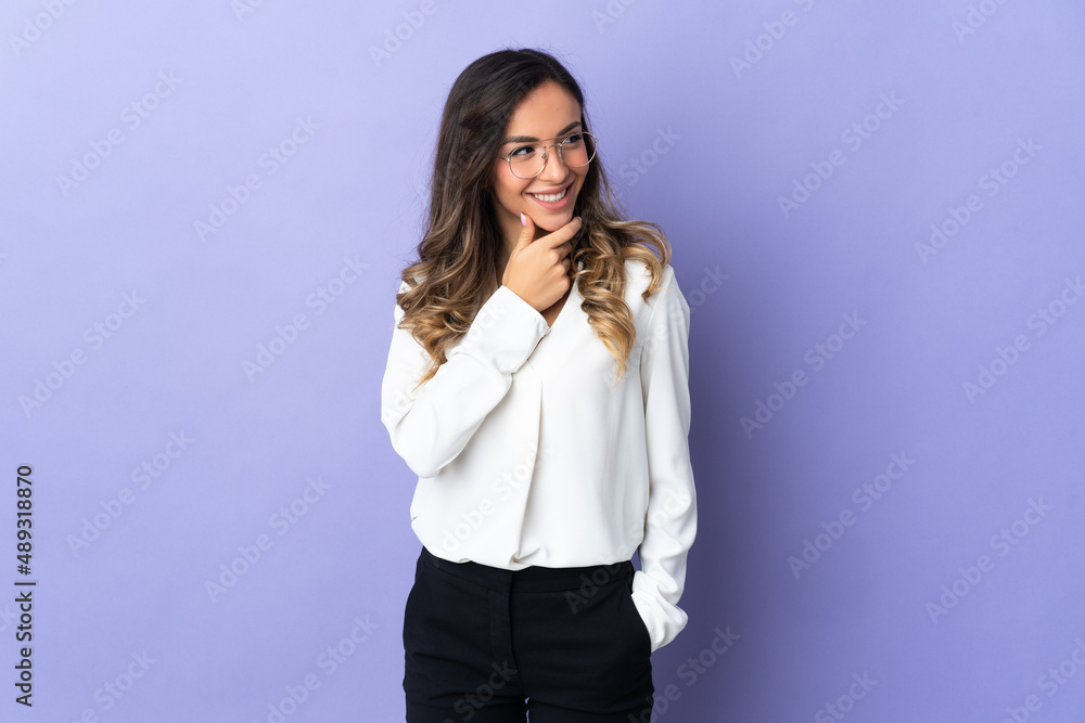 Young caucasian woman isolated on purple background looking to the side and smiling Young caucasian woman isolated on purple background looking to the side and smiling