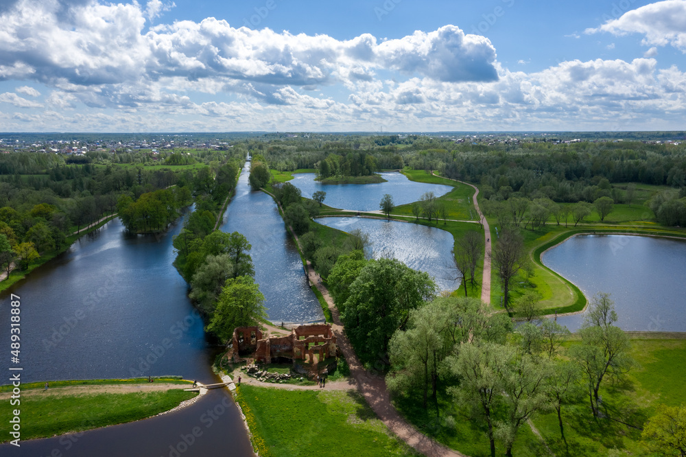 Fototapeta premium A panoramic view from a height of the ponds and the Landscape Park in Peterhof, the meadow garden, walking paths, the destroyed pavilion.