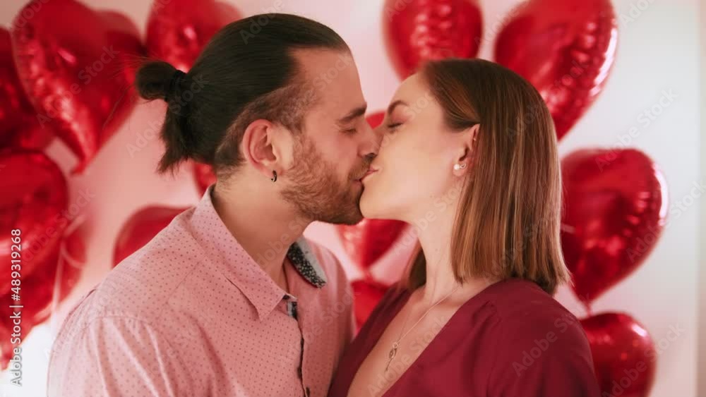 Close up portrait happy couple faces looking through fingers making heart shape Close up portrait happy couple faces looking through fingers making heart shape
