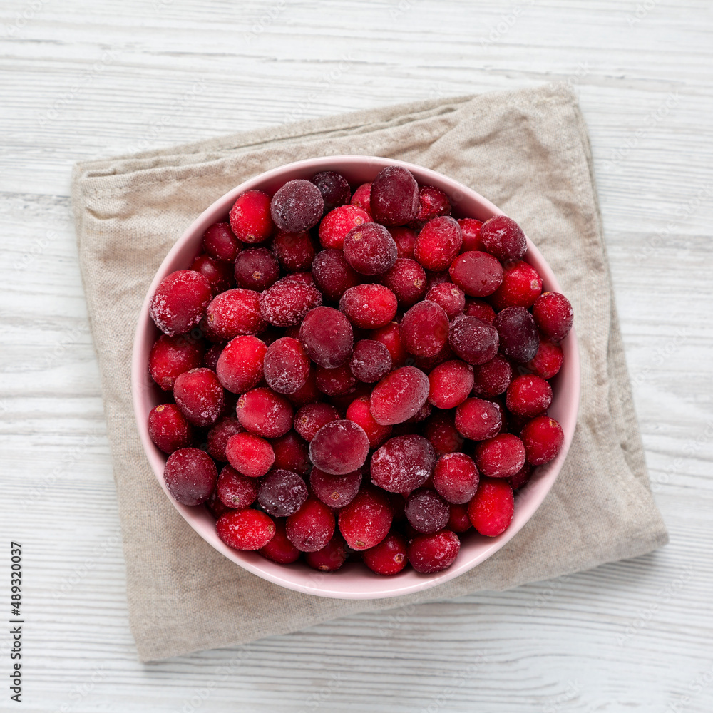 Frozen Cranberries in a Pink Bowl, top view. From above, flat lay, overhead. Frozen Cranberries in a Pink Bowl, top view. From above, flat lay, overhead.