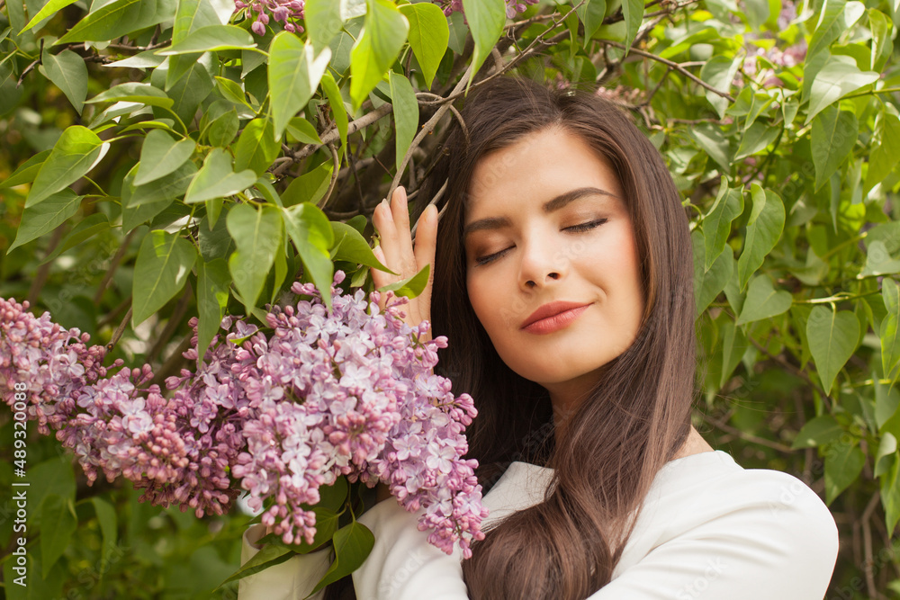 Calm portrait of pretty woman in blooming bush with lilac flowers Calm portrait of pretty woman in blooming bush with lilac flowers