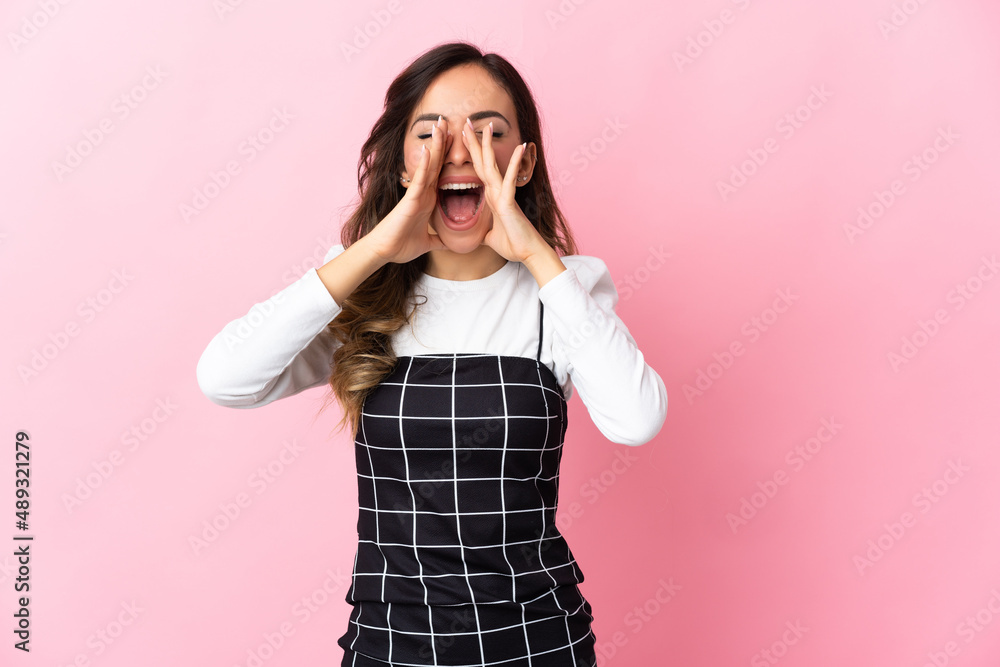 Young caucasian woman isolated on pink background shouting and announcing something Young caucasian woman isolated on pink background shouting and announcing something