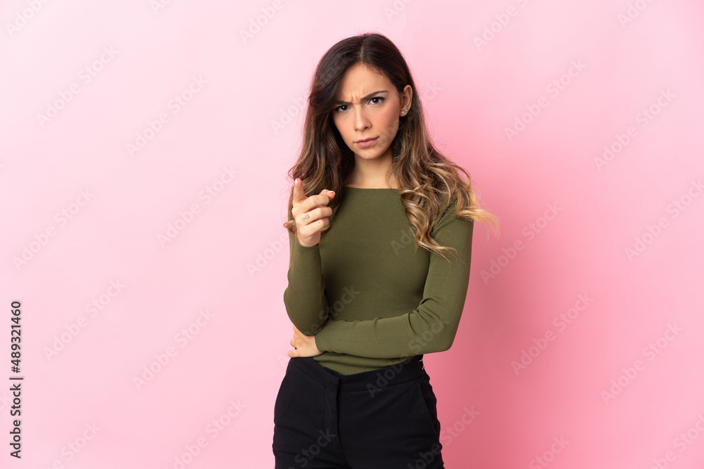 Young caucasian woman isolated on pink background frustrated and pointing to the front Young caucasian woman isolated on pink background frustrated and pointing to the front