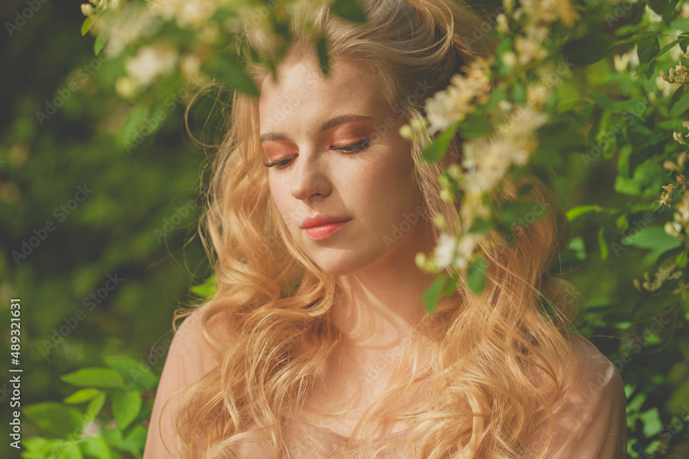 Attractive blonde woman relaxing outdoors on spring nature background Attractive blonde woman relaxing outdoors on spring nature background