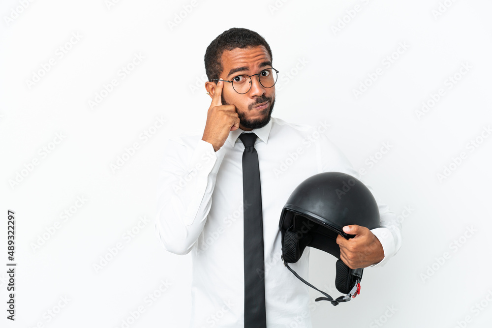 Naklejka premium Young business latin man with a motorcycle helmet isolated on white background thinking an idea