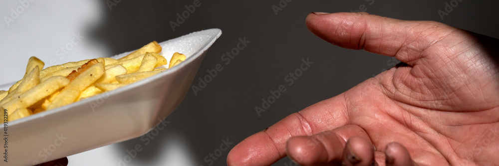 Panorama of fast food cook serving a portion of chips in a polystyrene food container at a market Panorama of fast food cook serving a portion of chips in a polystyrene food container at a market