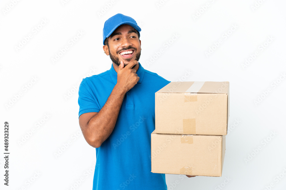 Delivery Ecuadorian man isolated on white background looking to the side and smiling Delivery Ecuadorian man isolated on white background looking to the side and smiling