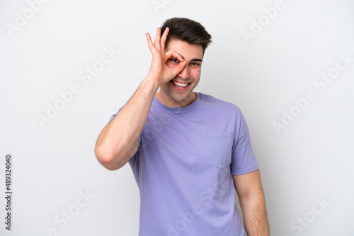 Young caucasian man isolated on white background showing ok sign with fingers