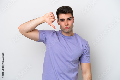 Young caucasian man isolated on white background showing thumb down with negative expression