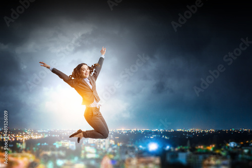 Portrait of energetic businesswoman jumping in open air © Sergey Nivens
