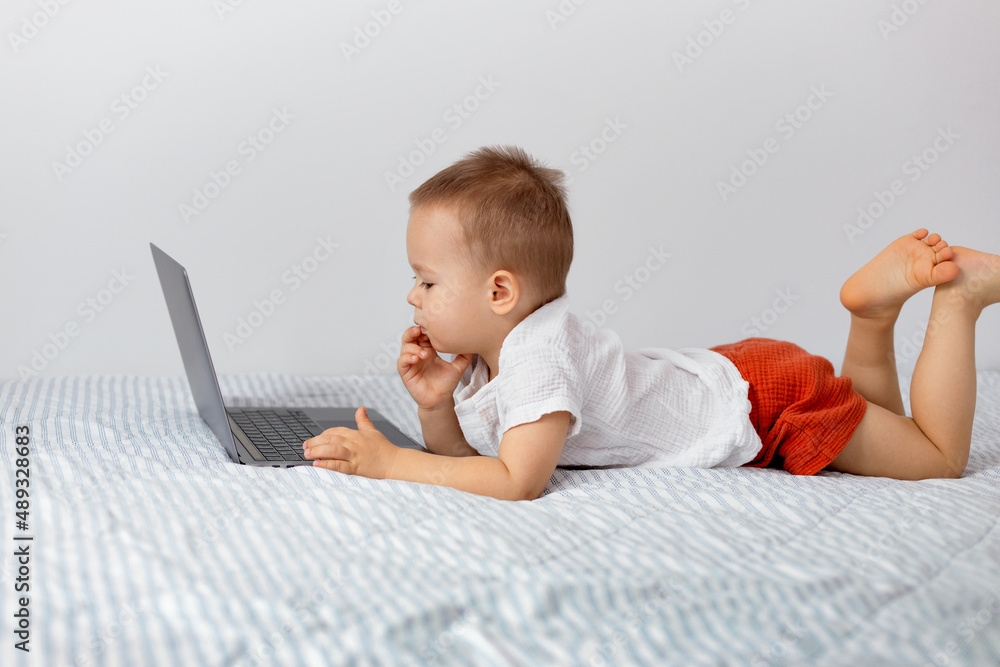 portrait of a child with a laptop, the child looks at the open screen portrait of a child with a laptop, the child looks at the open screen