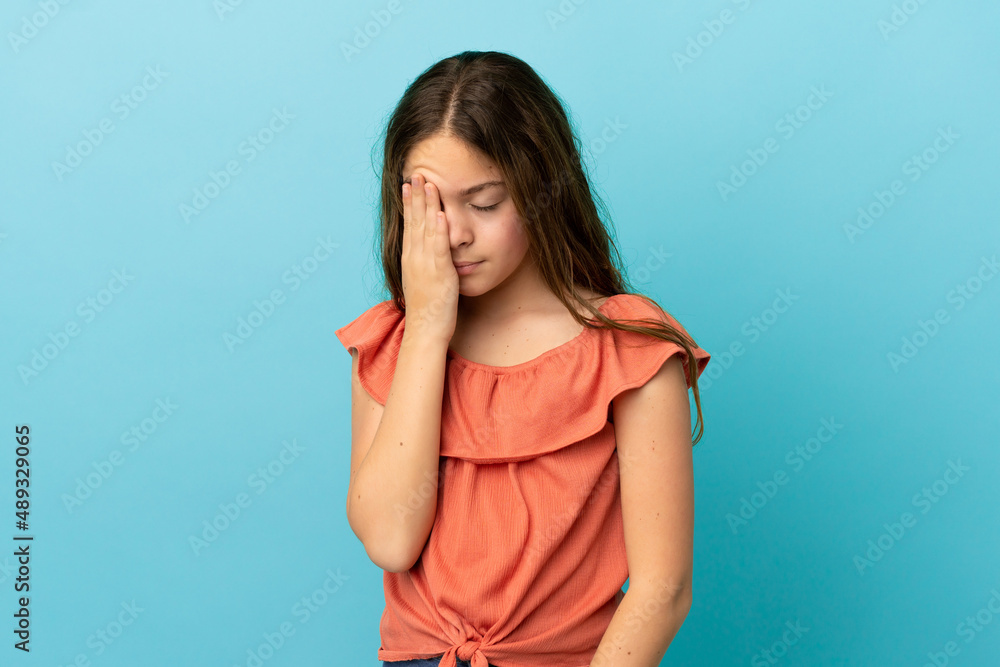 Little caucasian girl isolated on blue background with headache Little caucasian girl isolated on blue background with headache