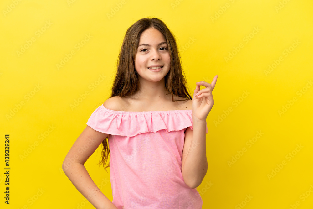 Little caucasian girl isolated on yellow background showing and lifting a finger in sign of the best Little caucasian girl isolated on yellow background showing and lifting a finger in sign of the best