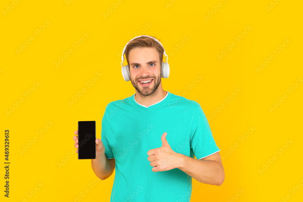 The best phone. Happy guy give thumbs up to mobile phone. Use it to make you feel different