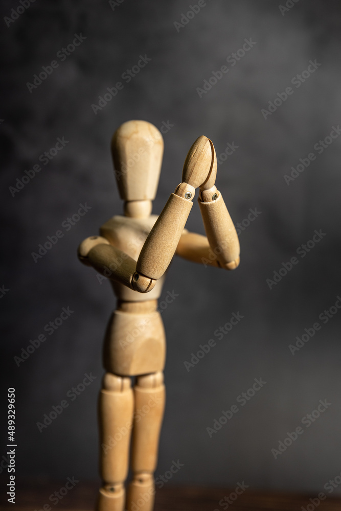 wooden figure of a person praying, dark background wooden figure of a person praying, dark background