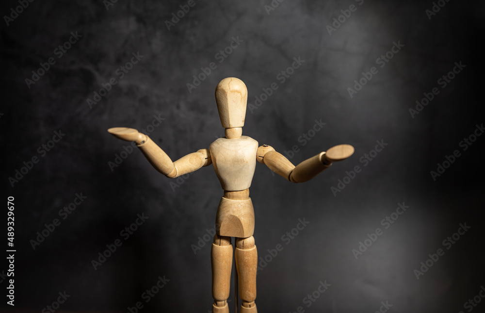wooden mannequin opening its arms, dark blackground wooden mannequin opening its arms, dark blackground