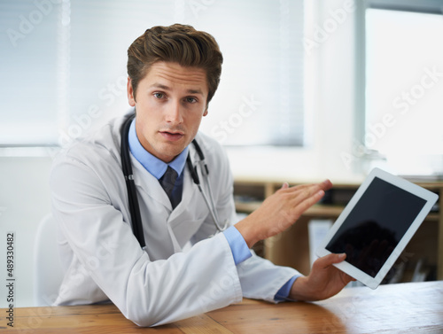 We have a treatment for this. Shot of a young doctor explaining something while holding a digital tablet.