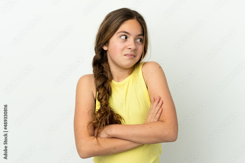 Little caucasian girl isolated on white background making doubts gesture while lifting the shoulders