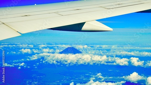 飛行機の窓から見た雲海の合間に見える富士山