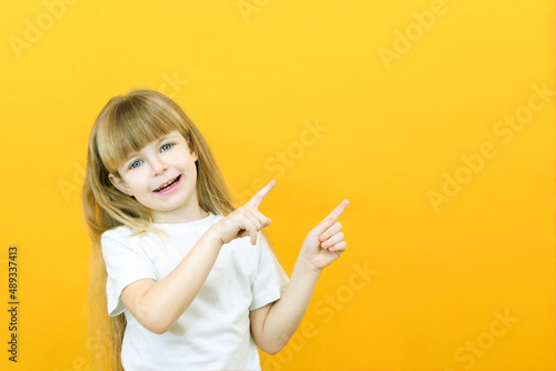 Wow  look  advertise here  Portrait of an amazed cute girl pointing at an empty space in the background  a preschool girl