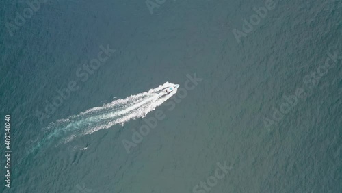 A speed boat is riding on the pacific filmed by a drone photo