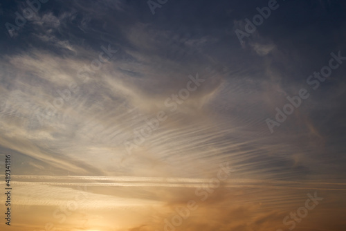 Sunset sky  clouds illuminated by the sun. Contrails and feather clouds. 