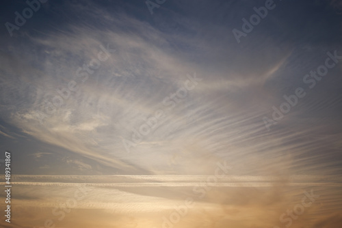 Sunset sky, clouds illuminated by the sun. Contrails and feather clouds. 