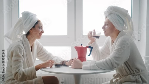 a young loving couple are sitting at a table and drinking coffee enjoying the time spent with each other