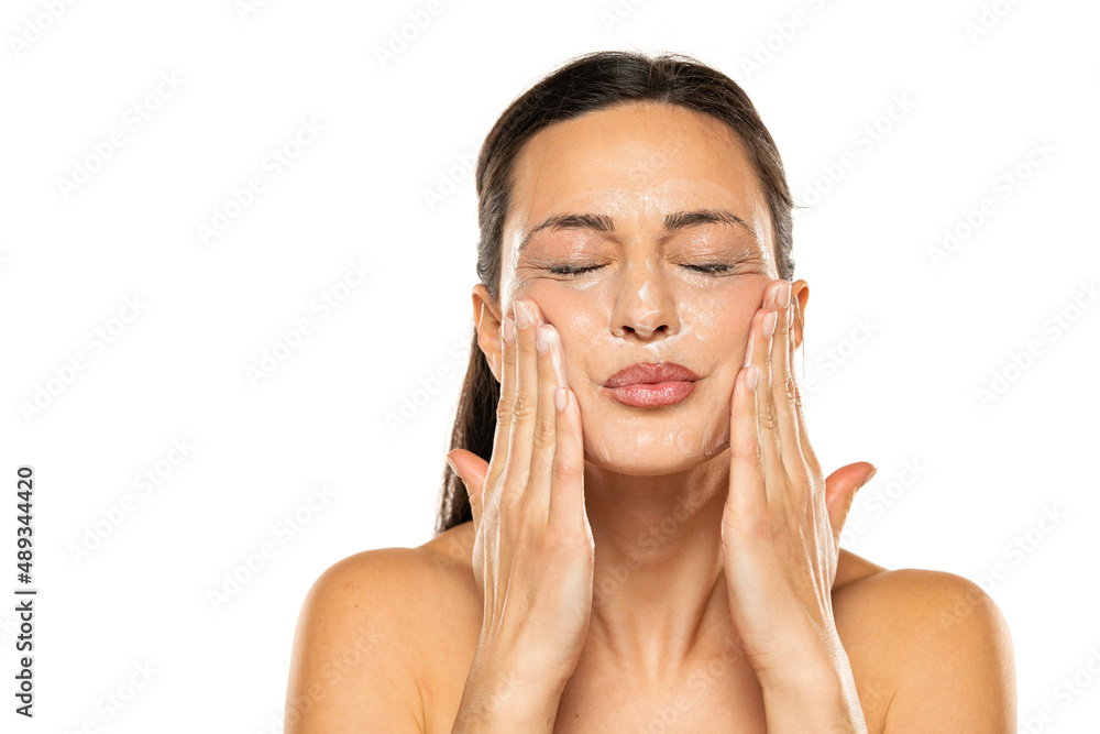 Young woman applies face cleaning product before remove it Young woman applies face cleaning product before remove it