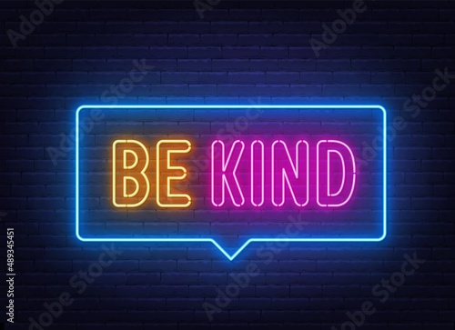 Be Kind neon sign on brick wall background.