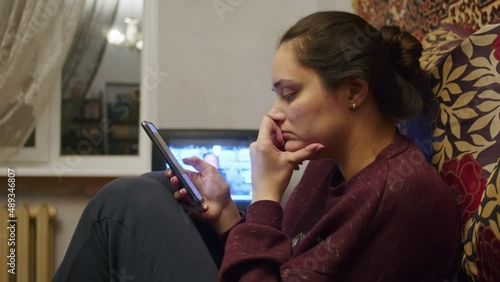 a sad girl watches the terrible news about the Russian offensive on the territory of Ukraine on a smartphone. News about tensions between Ukraine and Russia. Russian aggression. The threat of war