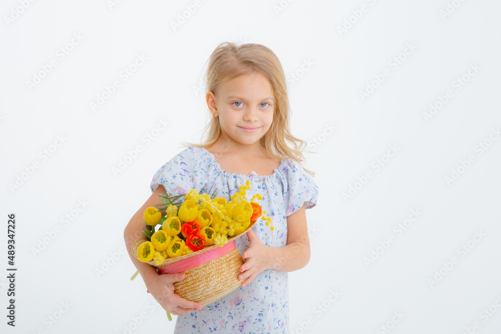 cute little blonde girl in a dress holding a bouquet of spring flowers on a white background. A child holds a bouquet of yellow tulips isolated on a white background. cute little blonde girl in a dress holding a bouquet of spring flowers on a white background. A child holds a bouquet of yellow tulips isolated on a white background.