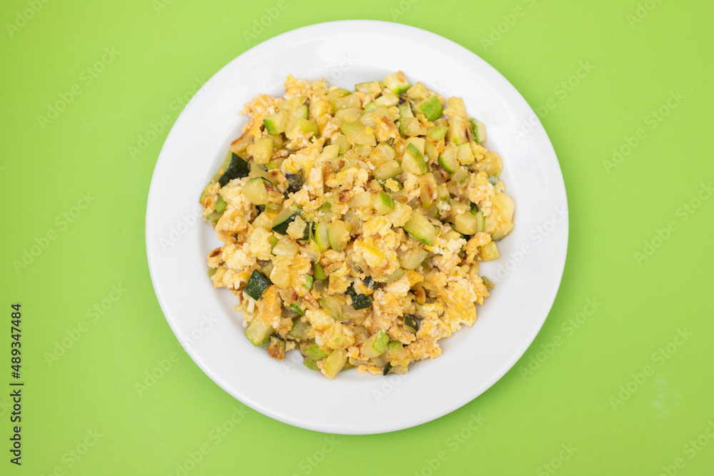scrambled egg with zucchini on white small plate scrambled egg with zucchini on white small plate