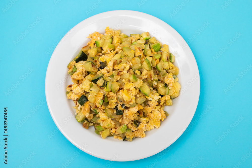 scrambled egg with zucchini on white small plate scrambled egg with zucchini on white small plate