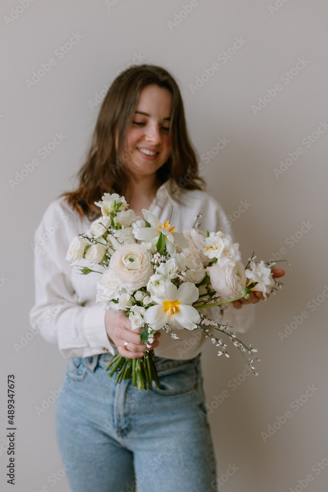 Young beautiful woman with a bouquet of flowers in her hands Gift for March 8 Women's holiday Young beautiful woman with a bouquet of flowers in her hands Gift for March 8 Women's holiday