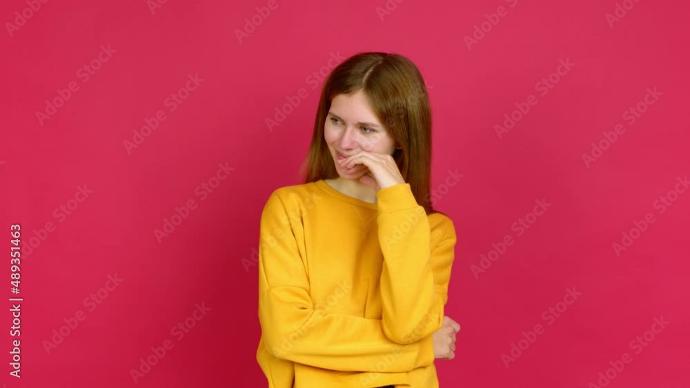 Young woman standing and looking to the side over isolated background Young woman standing and looking to the side over isolated background