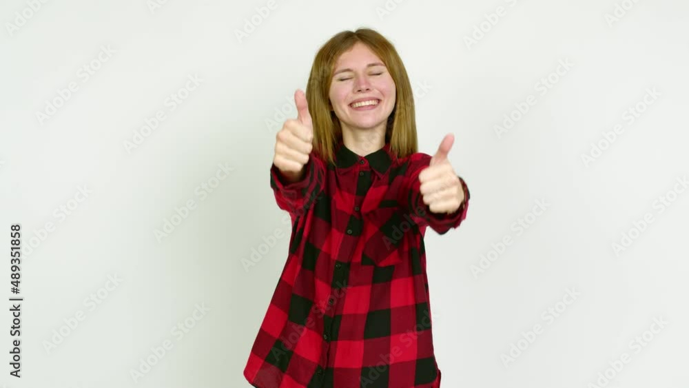 Young woman giving thumbs up and smiling because something good has happened over isolated background Young woman giving thumbs up and smiling because something good has happened over isolated background
