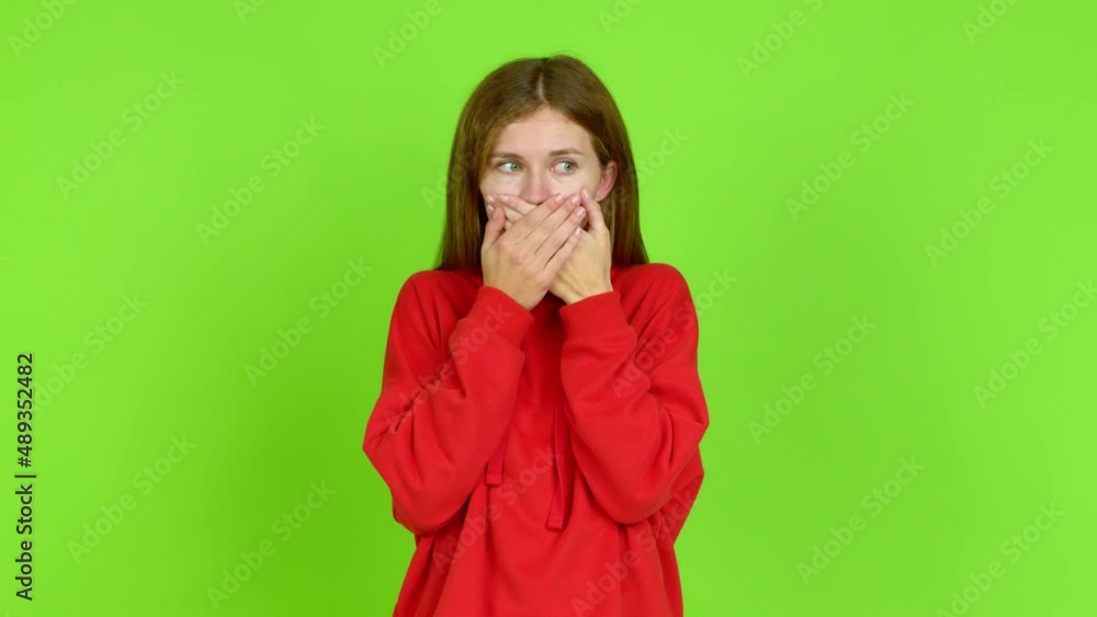 Young woman covering mouth with hands. Can not speak over isolated background. Green screen chroma key Young woman covering mouth with hands. Can not speak over isolated background. Green screen chroma key