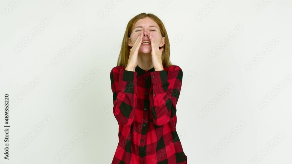 Young woman shouting and announcing something over isolated background Young woman shouting and announcing something over isolated background