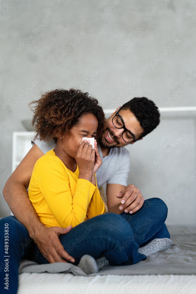 Father caring for black daughter who is sick from flu or coronavirus
