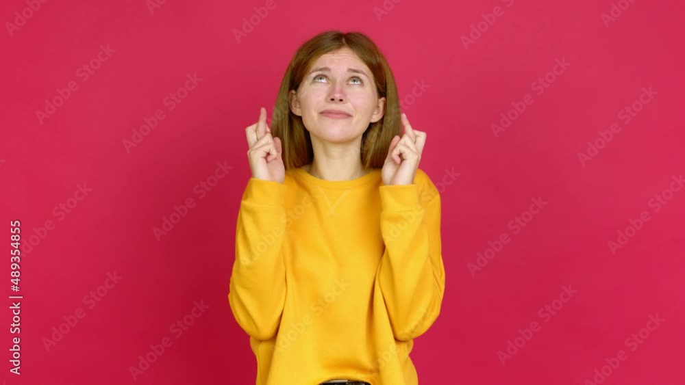 Young woman with fingers crossing and wishing the best. Making a wish over isolated background Young woman with fingers crossing and wishing the best. Making a wish over isolated background