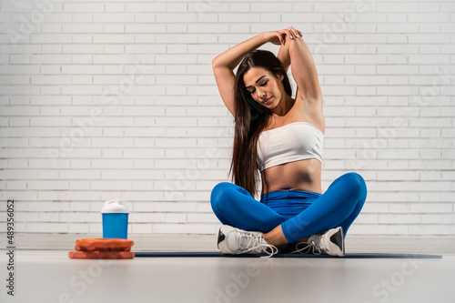 Guapa mujer deportista con mallas azules haciendo yoga y estiramientos 